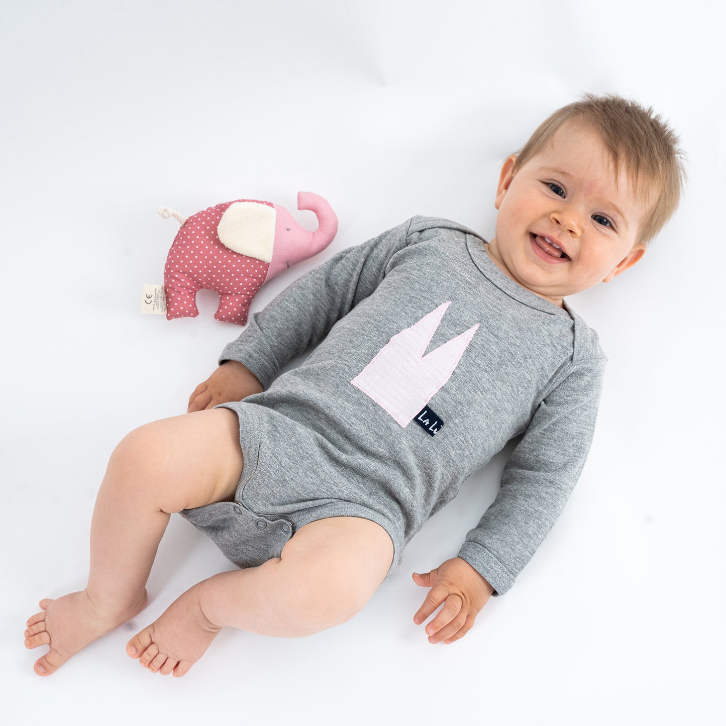 Baby mit Bio-Baumwoll-Body in Pastellfarben mit Dom