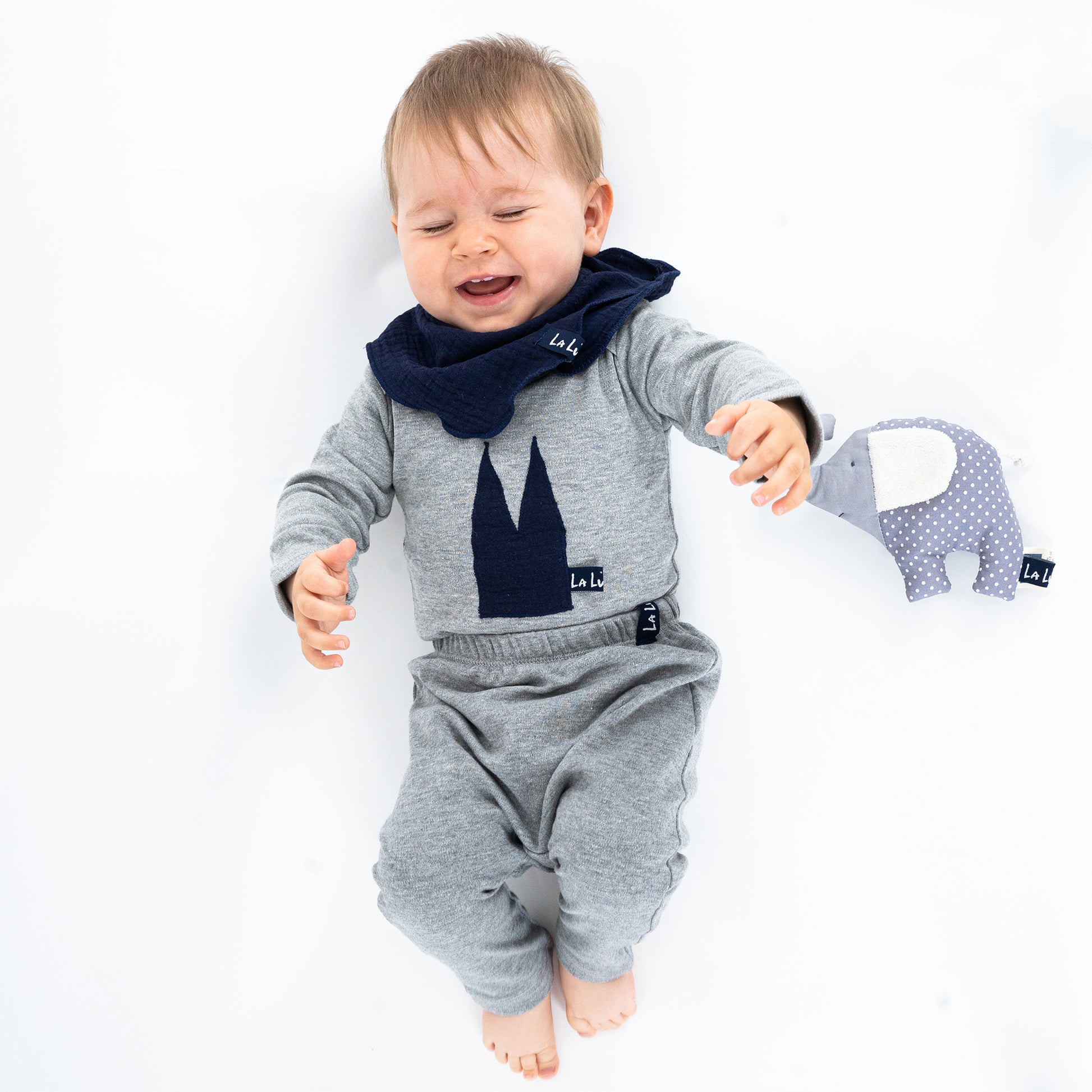 Baby mit Bio-Baumwoll-Body in Pastellfarben mit Dom
