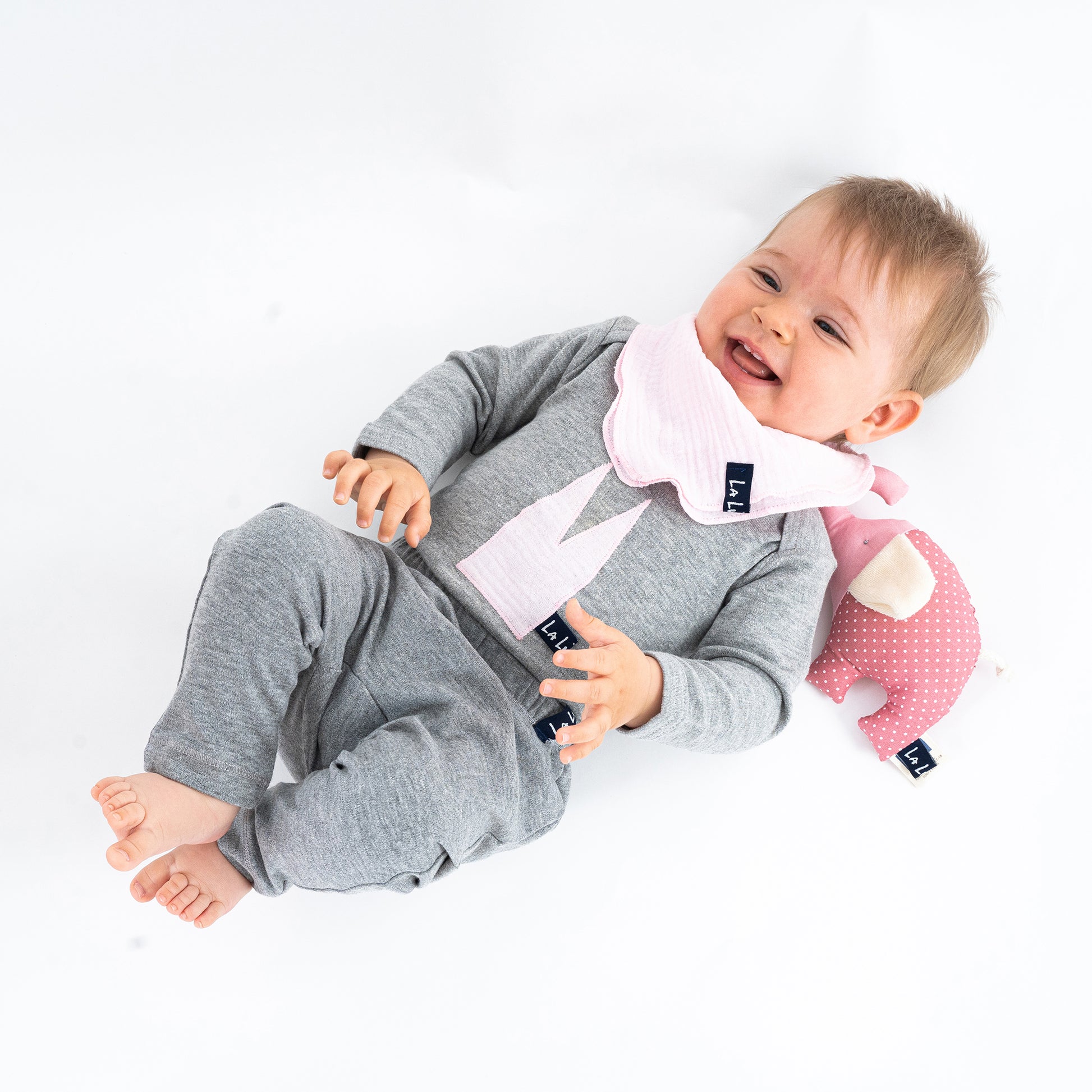 Baby mit Bio-Baumwoll-Body in Pastellfarben mit Dom